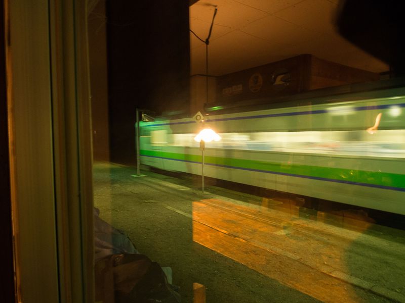 「駅の宿ひらふ」の窓の向こうを走り去る列車