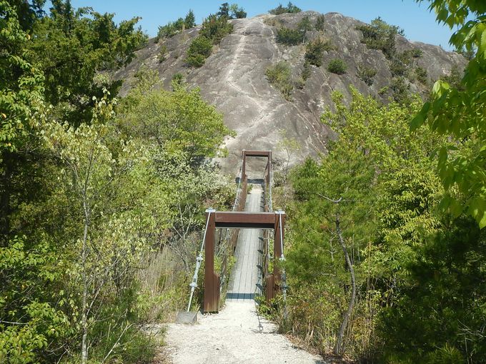 吊り橋の向こうに巨大な磨崖仏